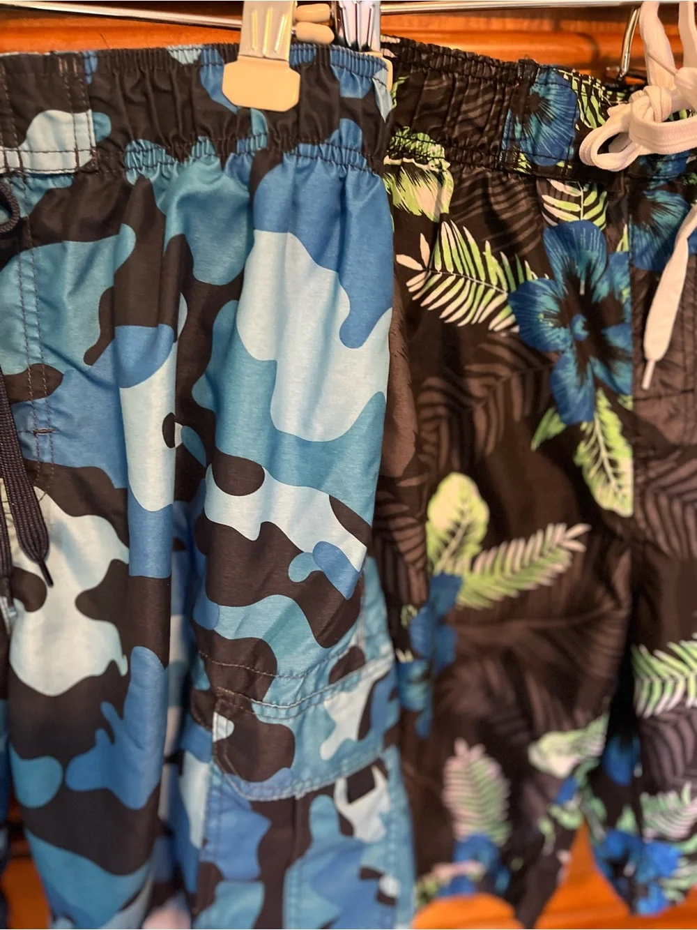 Pair of Kanu Surf Men's Blue Camo & Black Floral Swim Trunks